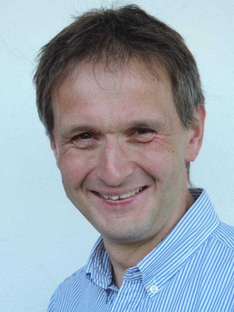 Stefan in gestreiftem Hemd vor weißem Hintergrund"
